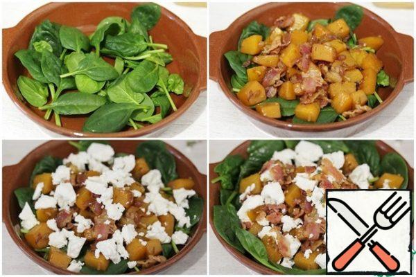 In a bowl, put the spinach, put the pumpkin mixture on it.
Top with crumbled cheese.

You can sprinkle the salad with olive oil and add a little fresh thyme and pumpkin seeds, but this is not necessary.