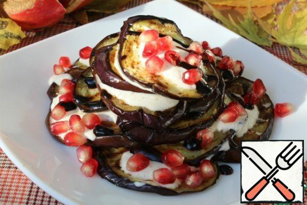 We spread the eggplants in a slide.
For each eggplant, a little sauce.
Add balsamic cream and sprinkle with pomegranate seeds.