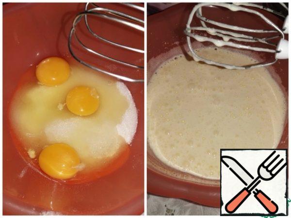 Beat the eggs with vanilla sugar, a pinch of salt and sugar until white and the mass increases in volume. Pour in the corn oil and stir.