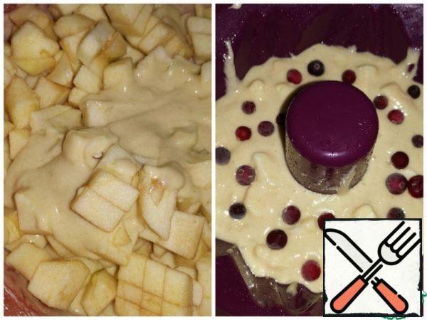 Wash the apples, peel them, and cut them into medium-sized cubes.
Stir into the dough. Put half of the future cake in a greased form, throw the cranberries (if desired), spread the remaining half of the dough on top.
