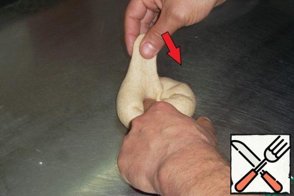 Pour a little oil on the table. Flatten the dough with an open palm in oil and pull it from the edges to the middle, pressing the middle of this "pancake" with your finger...