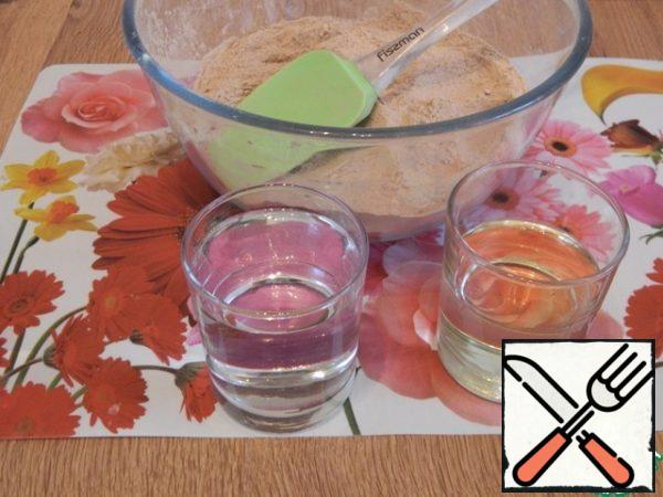Add the liquid components: 200 ml of water and 90 ml of vegetable oil. Let's make a batch of dough. In advance, turn on the oven to warm up to 190 degrees.