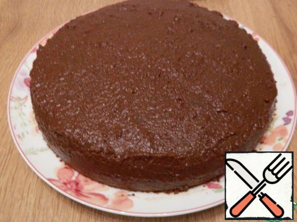 With a smaller part of the cream, we will smear and level the surface of the cake, slightly lubricate the sides to hide the seams.