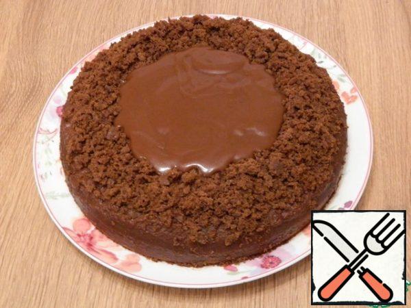 Pour the icing into the middle of the cake, the fence of crumbs does not allow the glaze to spread, it is thick, so it does not spread further.