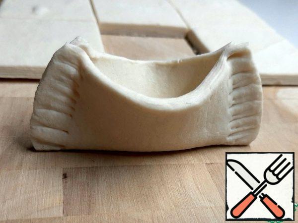 Secure the edges with a fork. Place on a baking sheet in the form of boats and slightly press down the bottom for stability. Bake at 180 degrees for 20 minutes until golden brown.