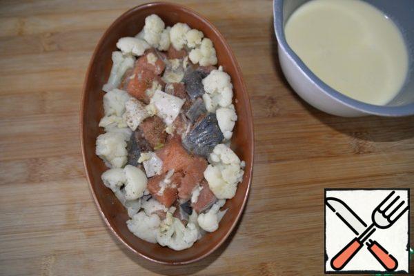 Put in the form of fish and cauliflower. Squeeze out the garlic, it should have been done immediately when marinating.