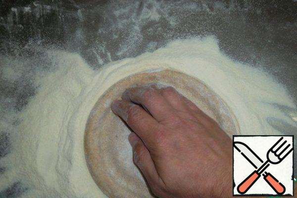 Pour the mixture on the table. The workpiece is slightly flattened with the palm of your hand, maintaining a round shape. We plan the sides. Just squeeze out the "circle" with your fingers at a distance of 1 cm from the edge of the workpiece. This is not necessary at all. After a few hundred rolls, the cooks stop doing such nonsense, but it's easier for beginners...