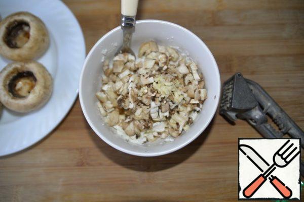 Add finely chopped legs of mushrooms, garlic through the press.