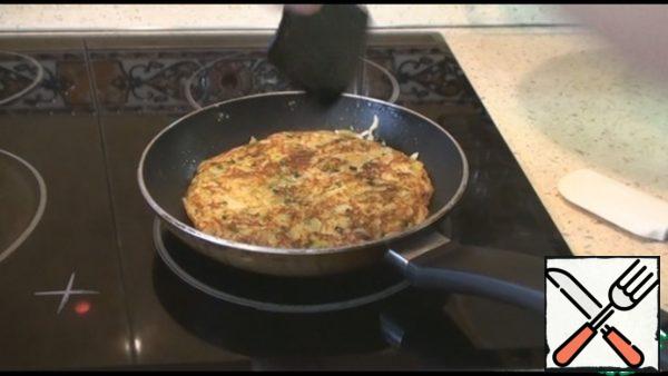With the help of a plate, turn the tortilla to the other side. Fry for 5 minutes and then another 2 minutes on both sides, so that the cabbage and carrots are fried. The fire is medium.