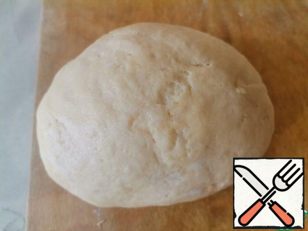 On a floured surface, knead a soft and elastic dough. Wrap it in plastic wrap and put it in the refrigerator for 20 minutes.