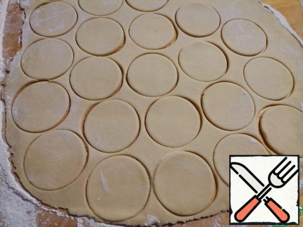 Roll out the dough into a thin layer, 0.5 cm thick. Cut out the circles.