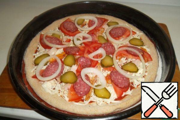 We spread the blank on what we will bake and collect pizza. At home I do not have a hearth stove, so I get out of the situation in a fairly simple way - I pour a pack of salt on the pallet and warm it up well in the oven. I collect the pizza on a silicone mat, then carefully transfer it to hot salt and send it to the oven.