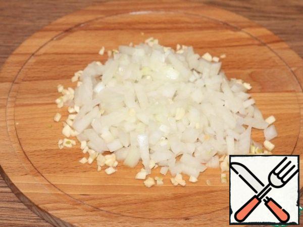 Let's prepare the vegetables. Finely chop the peeled onion and garlic and fry in hot oil until "transparent".