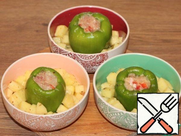 Lay out the potatoes in tins. Put the peppers in the middle.