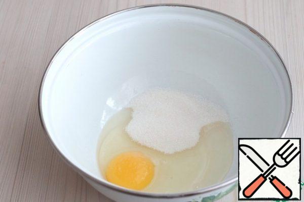 Add egg (1 pc.), Sugar (50 gr.) To a bowl. Beat the mixture until the sugar is completely dissolved.