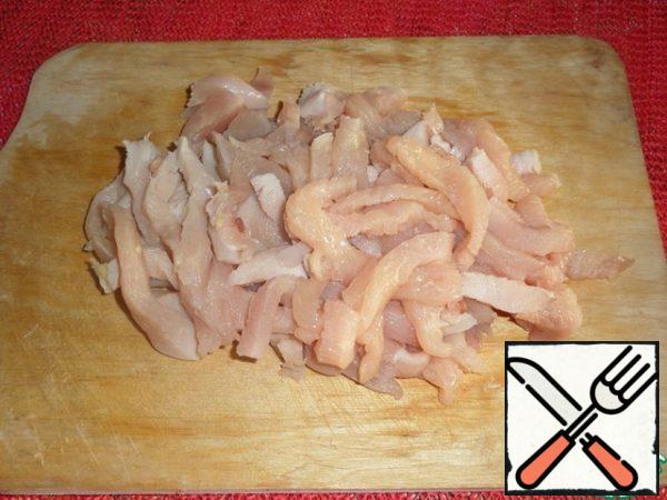 Cut the chicken into strips and place in a cup.