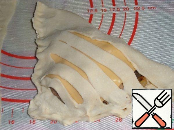 Pinch the pies, covering the filling with a corner of the dough with incisions.