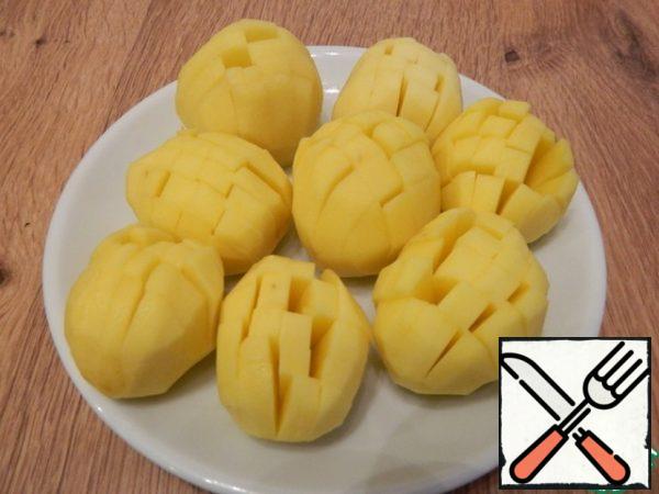 
Cut the potatoes up and down, but not completely, to make a flower. Cut a little from the bottom too, so that the potatoes stand steadily. Add salt.