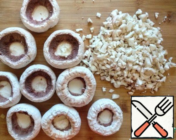 Carefully remove the legs from the mushrooms and finely chop them.