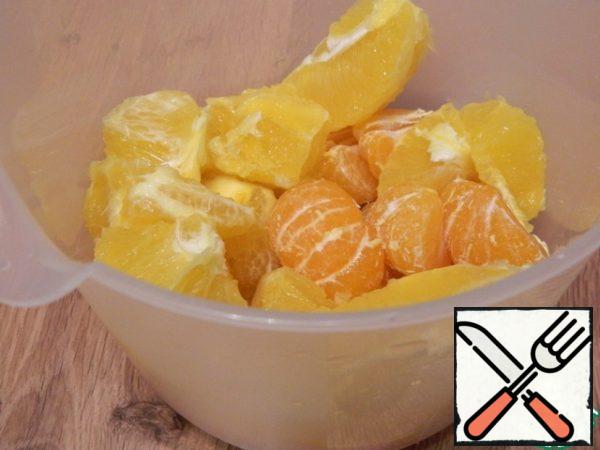 Let's peel the orange and tangerines. Place in a tall bowl. Grind with a blender.