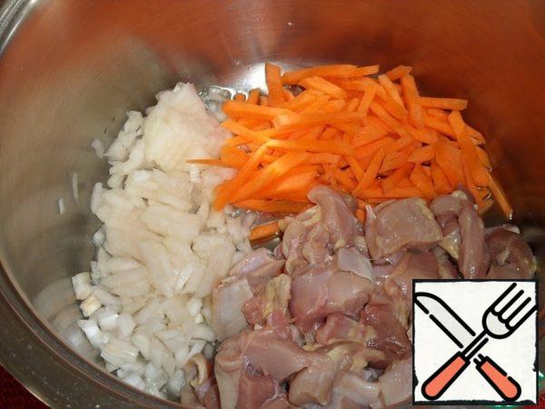 
Put a saucepan with a thick bottom on the fire. Pour vegetable oil into it and put onions, carrots and chicken meat.