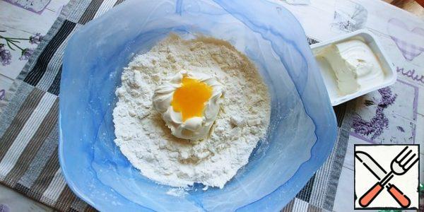 
Add half a box of cottage cheese, soft cheese and yolk, 3 tablespoons of rust. butter, baking powder and vanilla, knead thoroughly with a spoon and with your hands.