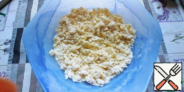
It turns out that this is not quite a homogeneous mass, but it's not scary. You can put a lot on the table, see how it suits you best. If it seems dry and does not want to collect in a ball, add one spoonful of water and continue kneading, but not for long, otherwise the dough will become tough.