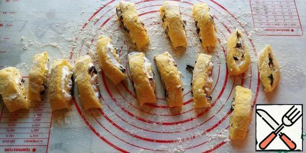 Cut the roll into not very thin pieces, about 1.5-2 cm. I have 14 pieces. Do not be alarmed that they are fragile and ugly, everything can be perfectly corrected on a baking sheet.