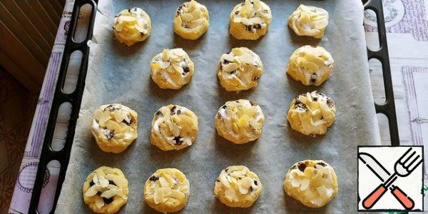 Line the baking sheet with baking paper, grease it with rast. butter, spread the cookies, straightening them. Sprinkle with almond petals on top, pressing them slightly on top.
We bake until golden brown, it took me about 20 minutes at a temperature of 180 grams