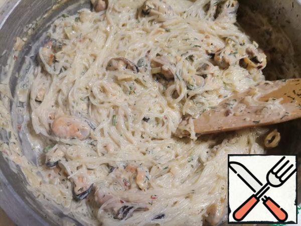 Add funchoza to the mussels in the sauce and mix thoroughly.