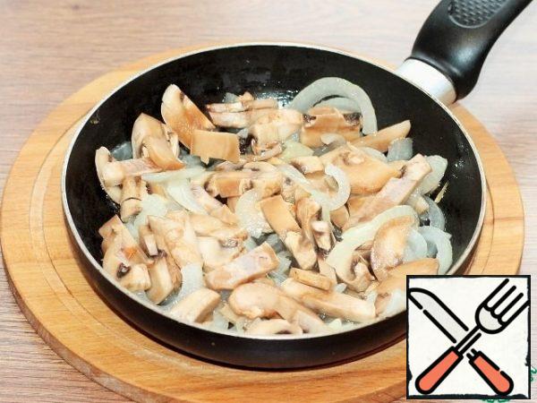 Cut the prepared champignons into slices and fry with the onion until half cooked.