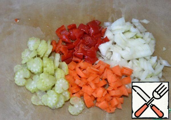 Clean the vegetables, wash. Cut celery into strips; onions, peppers and carrots in small cubes.