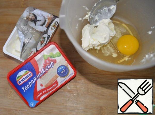 Take the curd cheese, egg and mix thoroughly with a fork or mixer.