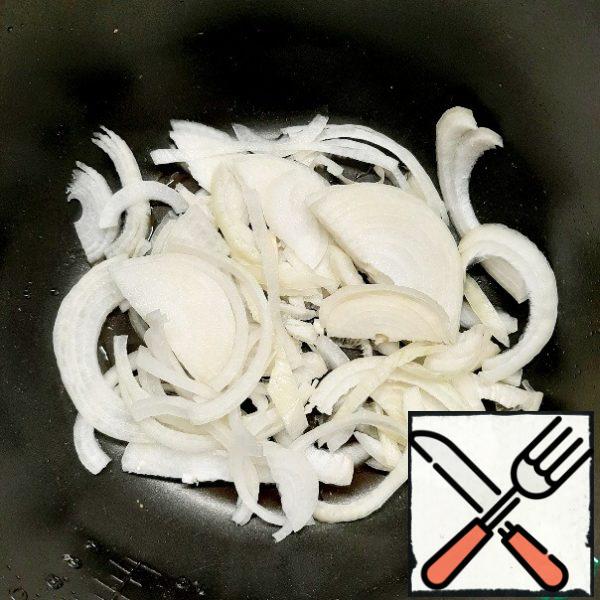 I cooked in a slow cooker, but you can cook in what is convenient for you.
Chop the onion into half rings and fry in oil together with the crushed garlic.