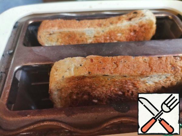 Slices of toast bread are fried in a toaster or in a frying pan. I have toasted rye bread with seeds.