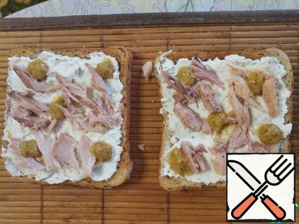Top with pieces of canned tuna and mustard.