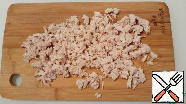 Chicken fillet is cut arbitrarily into small pieces. We send it to the salad bowl.