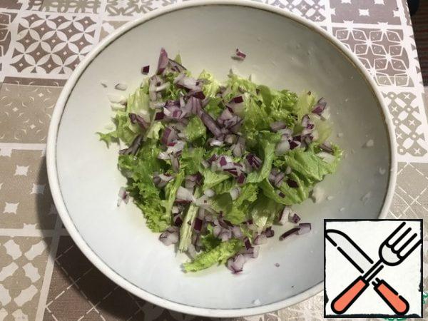 Finely chop the onion and put it on top of the salad.