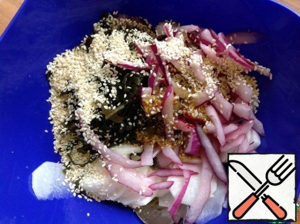 Drain the remaining liquid from the daikon. Add the seaweed, sesame seeds, and dressing. Drain the marinade from the onion and add the onion to the salad. Stir and let stand for 30 minutes.