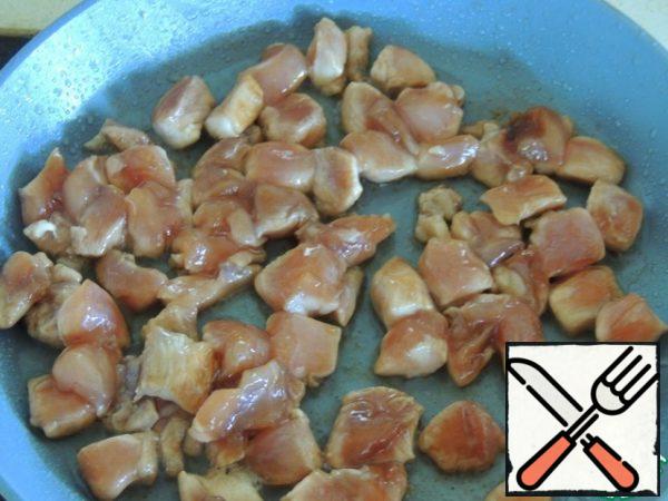 Cut the meat into cubes. In a frying pan, heat 3 tablespoons of vegetable oil and fry the chicken cubes until golden brown. Cool it down.