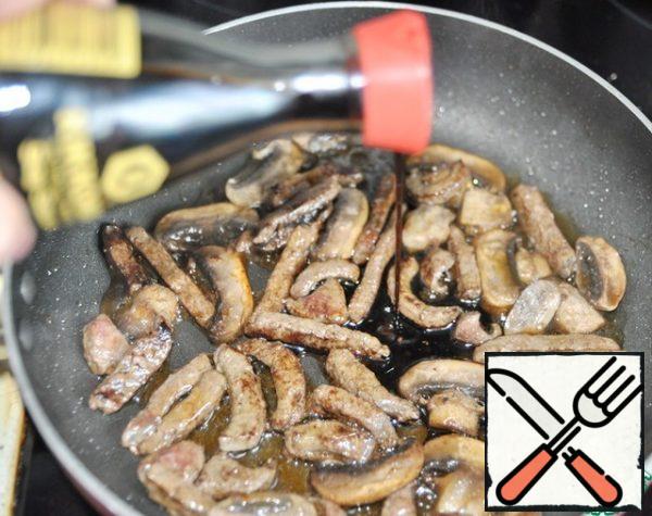Add soy sauce to the liver with mushrooms. Stir and simmer for a couple of minutes. Remove the pan from the stove, let it cool down a little.