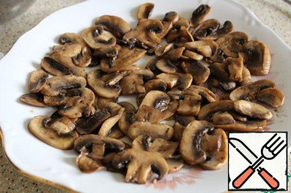 Spread the fried slices of mushrooms on the dish.