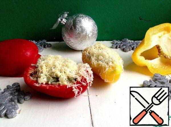 Grate the cheese on a fine grater. Put the salad in the pepper slices, garnish with grated cheese on top.
