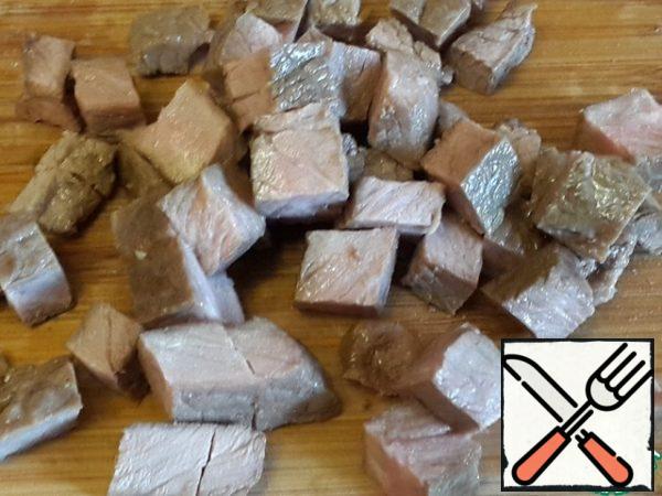 Sprinkle a piece of beef with salt and pepper on both sides and fry on the grill on both sides, cool, cover with a sheet of foil, cut into cubes.