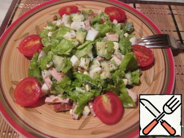Now we spread the salad on a serving dish, sprinkle with chopped walnuts and decorate with cherry halves.