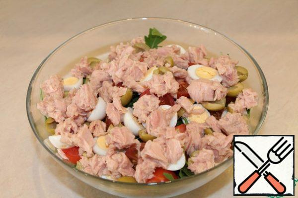 Then the olives... Mash the tuna a little with a fork in a jar and add to the salad bowl. 