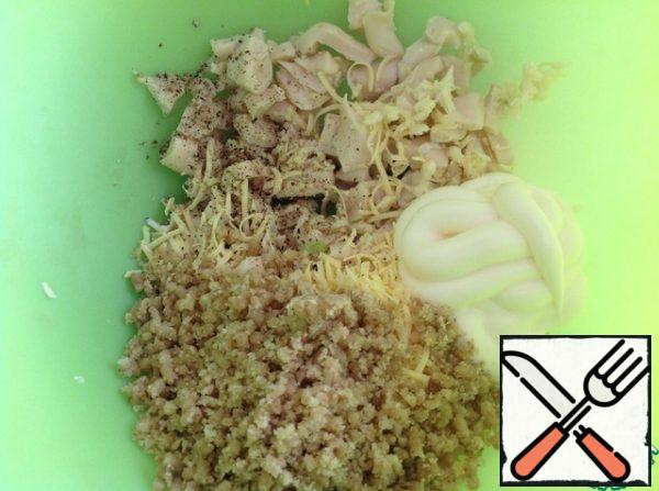 Put the nuts crushed in a meat grinder or blender, garlic passed through a press, mayonnaise and a mixture of peppers in a salad bowl.
Grate the cheese on a fine grater, cut the squid into cubes.
