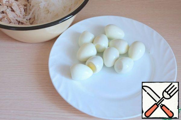 Boil the quail eggs and cut them into quarters.
