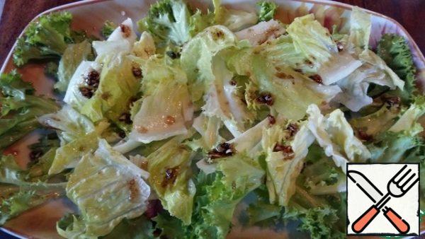 Wash and dry the salad. Tear into pieces, cut the tomatoes in half, throw the beans on a sieve, chop the garlic.