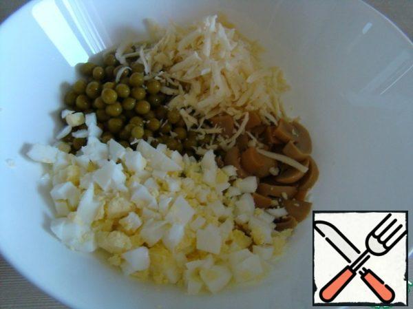 Cut the eggs into cubes, grate the cheese on a coarse grater.